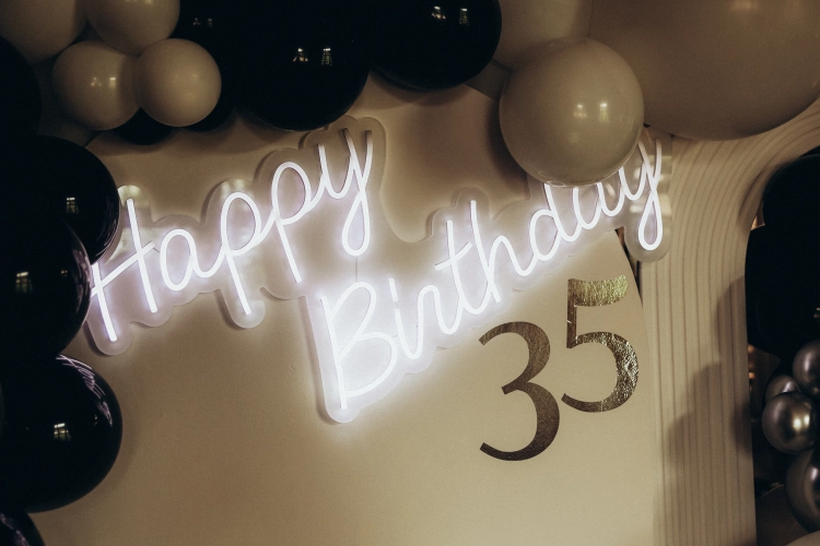 Podświetlany neon LED Happy Birthday i cyfra 35 na białej ściance z balonami